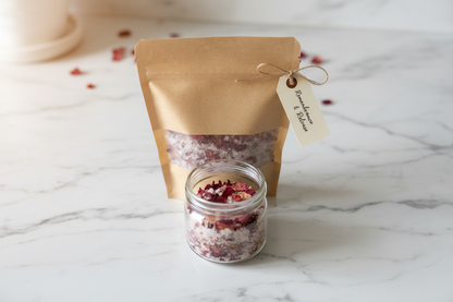 Sachet kraft de sel de bain et petit pot de cristaux roses sur une surface blanche